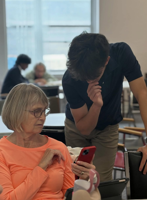 A TecNurtur volunteer helping an older adult use a smartphone