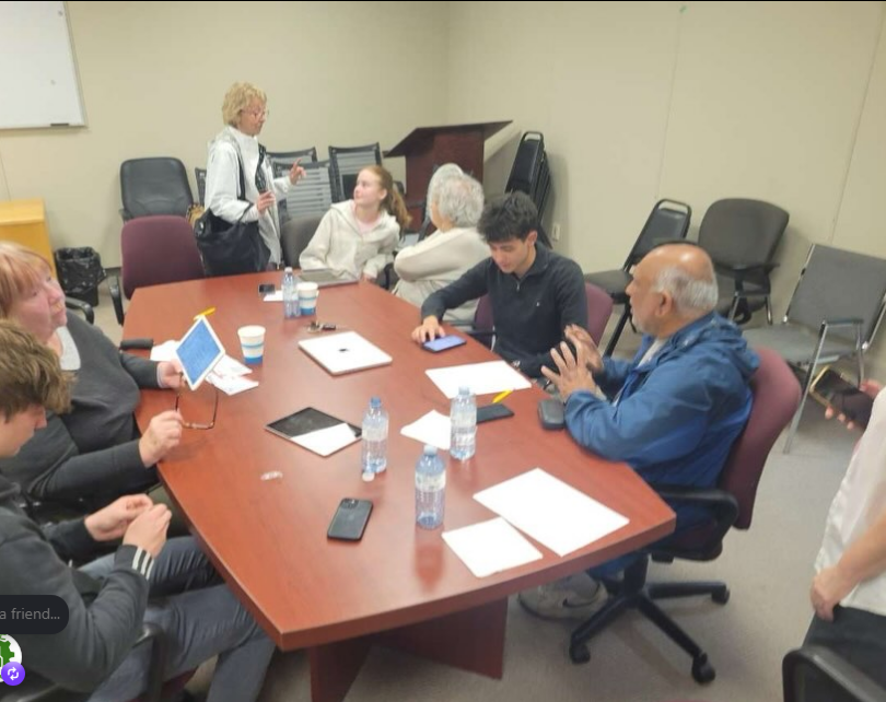 Community members collaborating around a table during a technology workshop